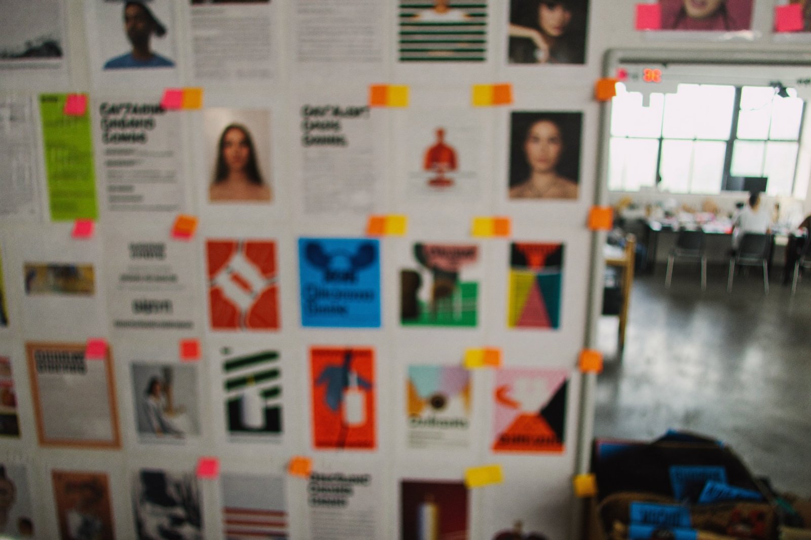 A production wall covered in printed ad variations and sticky notes in a creative studio